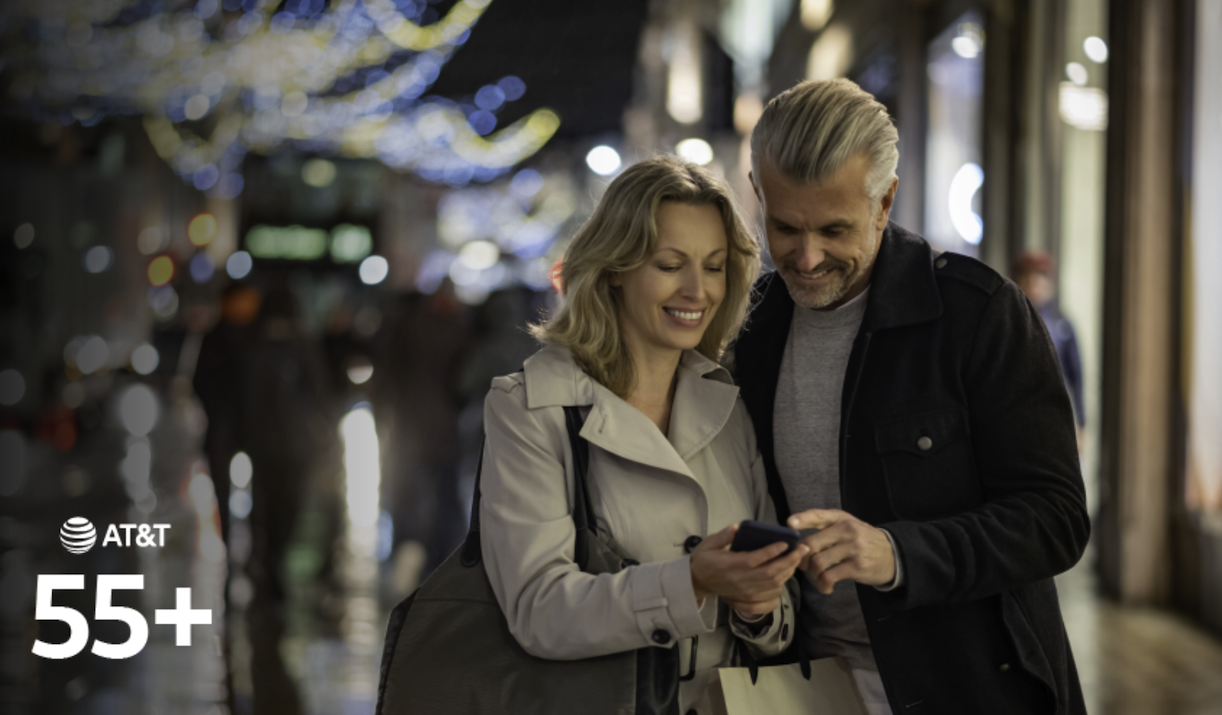 two senior citizens looking at their cell phone