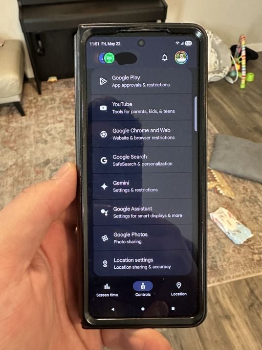 Person holding phone with Google Family Link open on the screen