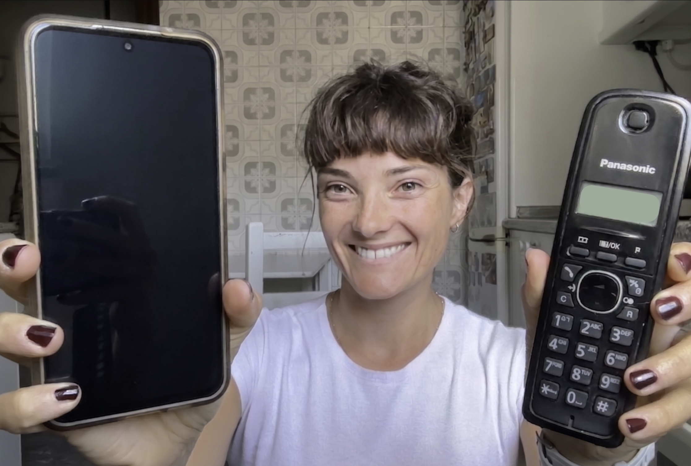 Jessica is holding up her Samsung S24 and her grandmother's old Panasonic landline.