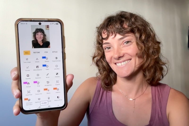 Jessica holding up her iPhone next to the App Store.